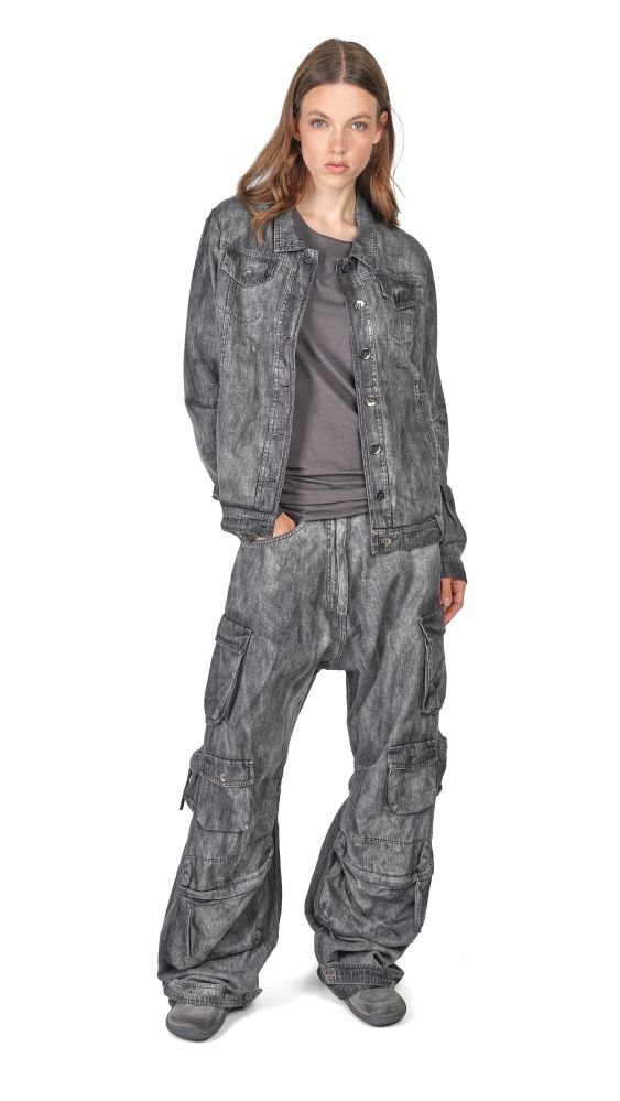 Frau trägt oversized Jeansjacke mit weiten, abgewetzten Cargo-Pantalons und grauer Bluse.