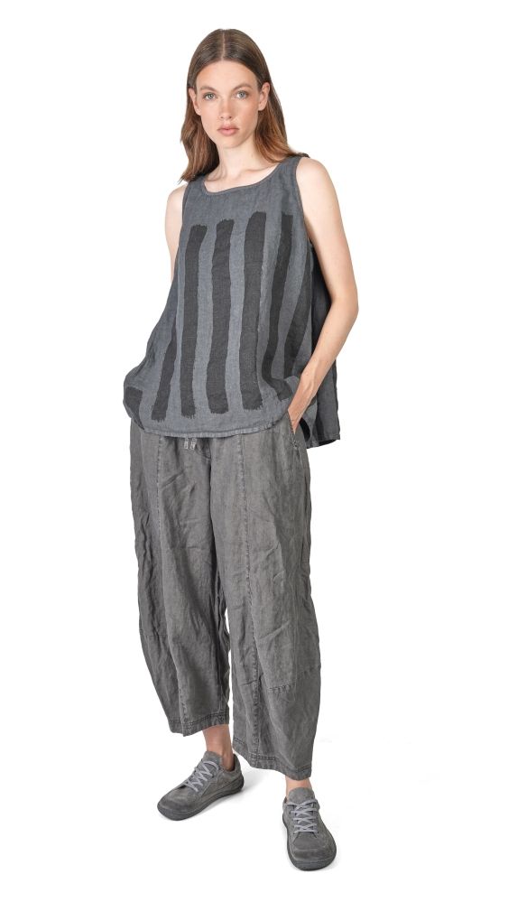 Frau trägt oversized gestreiftes Top und weite graue Hosen, bequeme Sneaker.