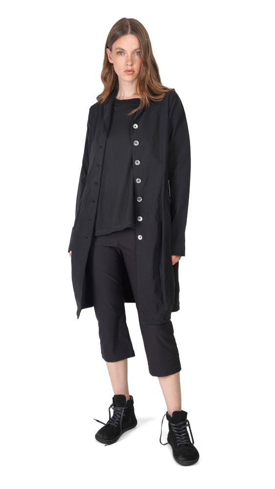 Frau trägt oversized schwarzen Blazer mit Knopfreihe, dazu schwarze Cargopants und robuste Schuhe.