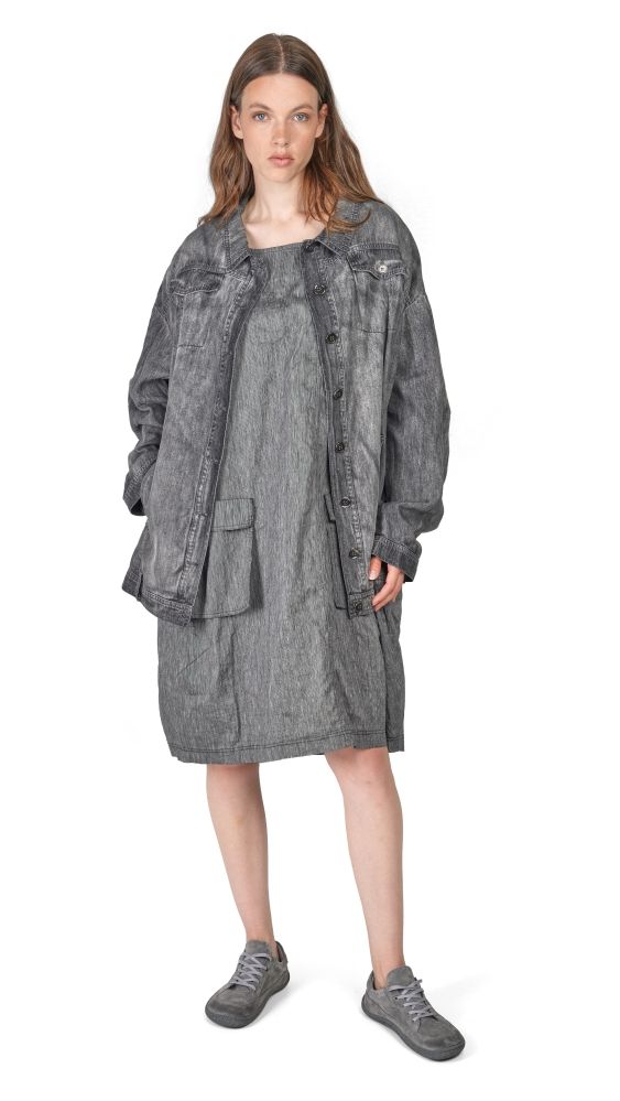 Frau trägt oversized graues Denim-Kleid mit Jacke und bequemen Sneakern.