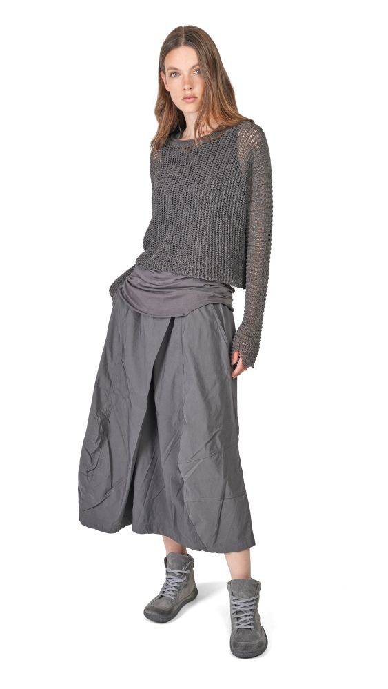 Frau trägt graues oversized Pulloverkleid mit weitem Rock und robusten Schuhen.