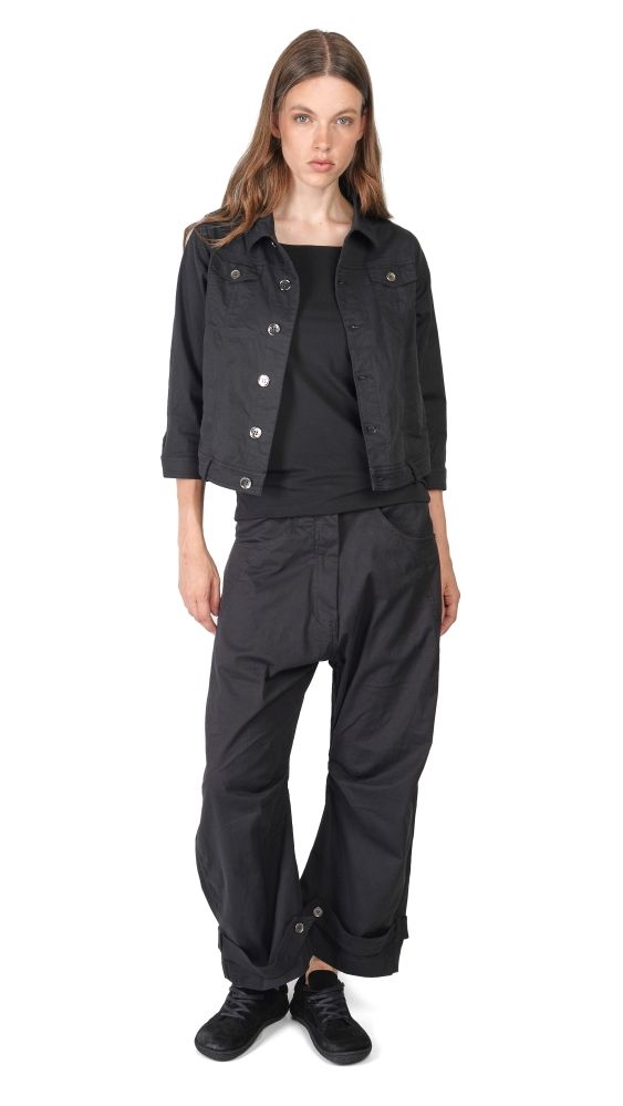 Schwarze Overalls mit kurzer Jacke, bequeme Schuhe, lässiger Stil.