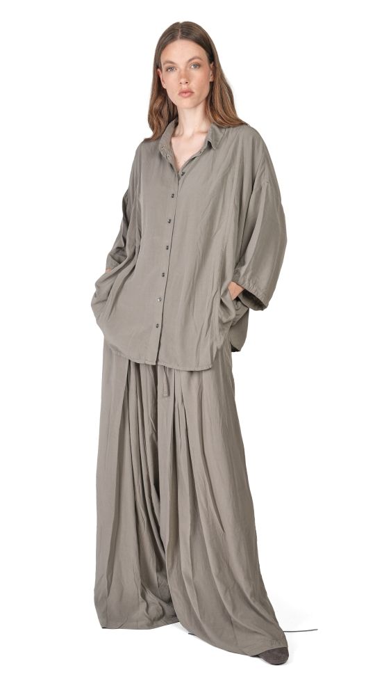 Frau trägt graues oversized Hemd mit weitem, langem Rock, lässiger Stil.