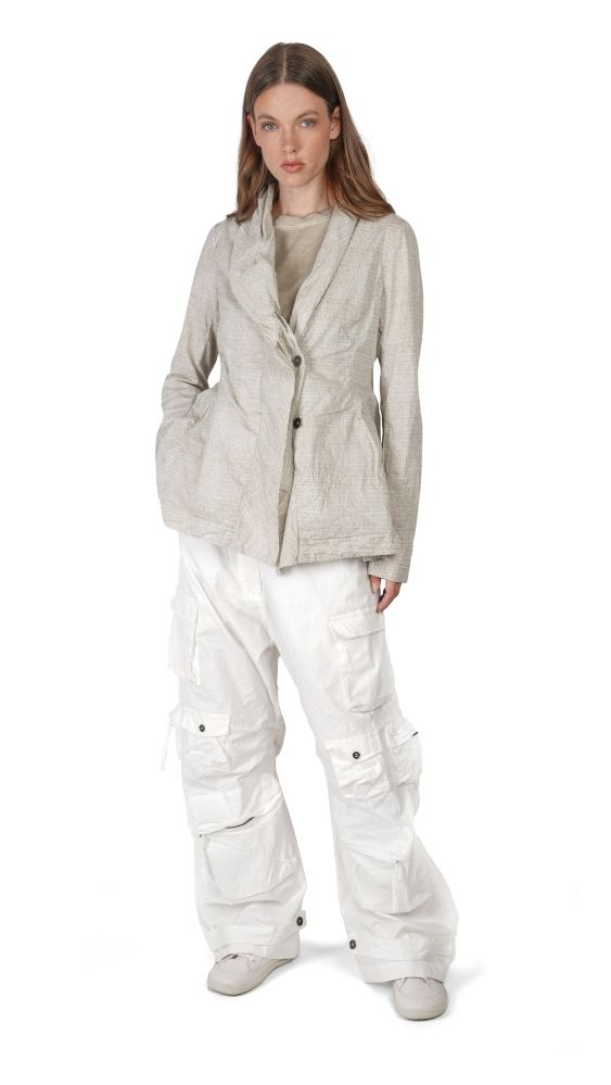 Frau trägt oversized beige Jacke mit weißen Cargo-Pantalons und Sneakern, lässiger Look.