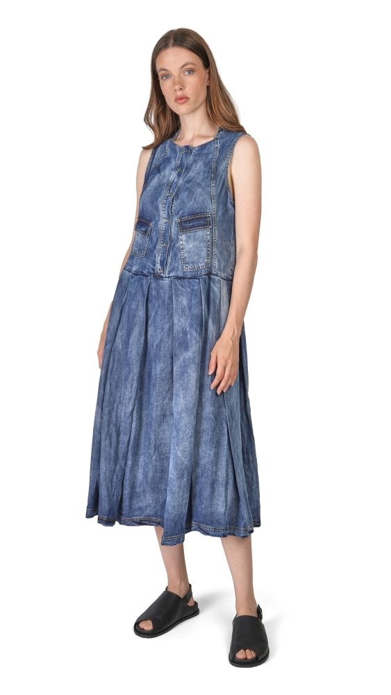 Frau trägt sleevless Jeckenkleid mit Patches und weitem Rock, schwarze Sandalen.