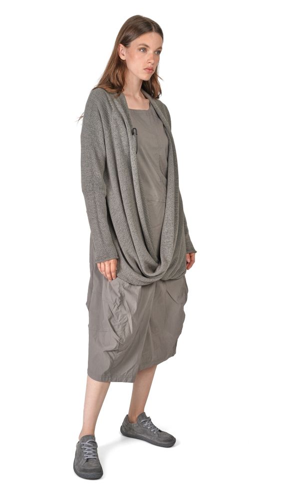 Frau trägt graues oversized Hemd mit weitem Rock und Sneakern, lässiger Look.