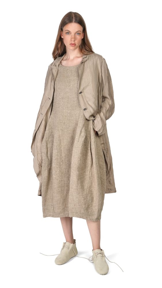 Frau trägt beiges, langes Überkleid mit Jackenärmeln und bequemen Schuhen.