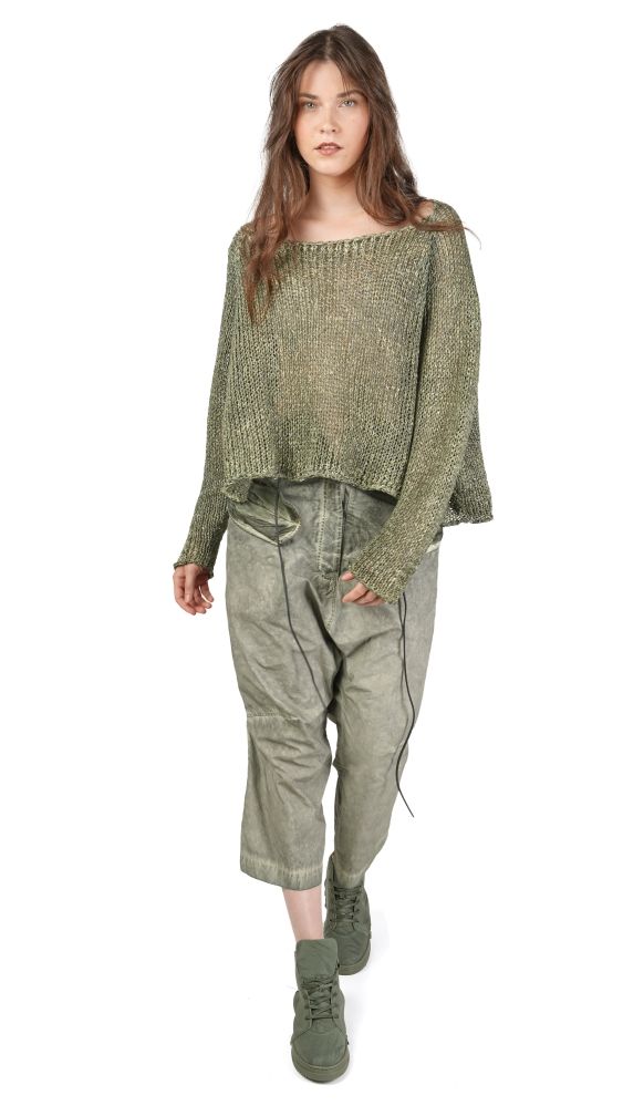 Frau trägt oversize-kariertes Top mit weitem Schnitt und grüne, weit geschnittene Hosen sowie grüne Sneaker.