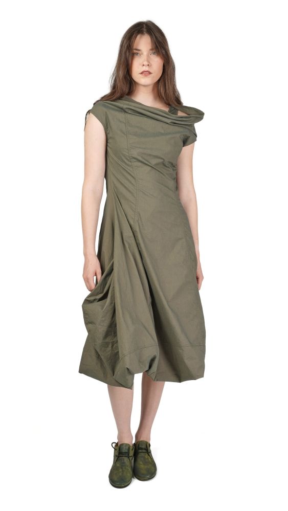 Frau trägt olivgrünes, weites Wickelkleid mit asymmetrischen Ärmeln und flachen Schuhen.