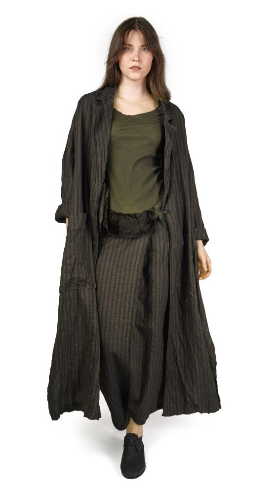 Frau trägt langes, gestreiftes Cape-Kleid mit grünem Top und schwarzen Schuhen.