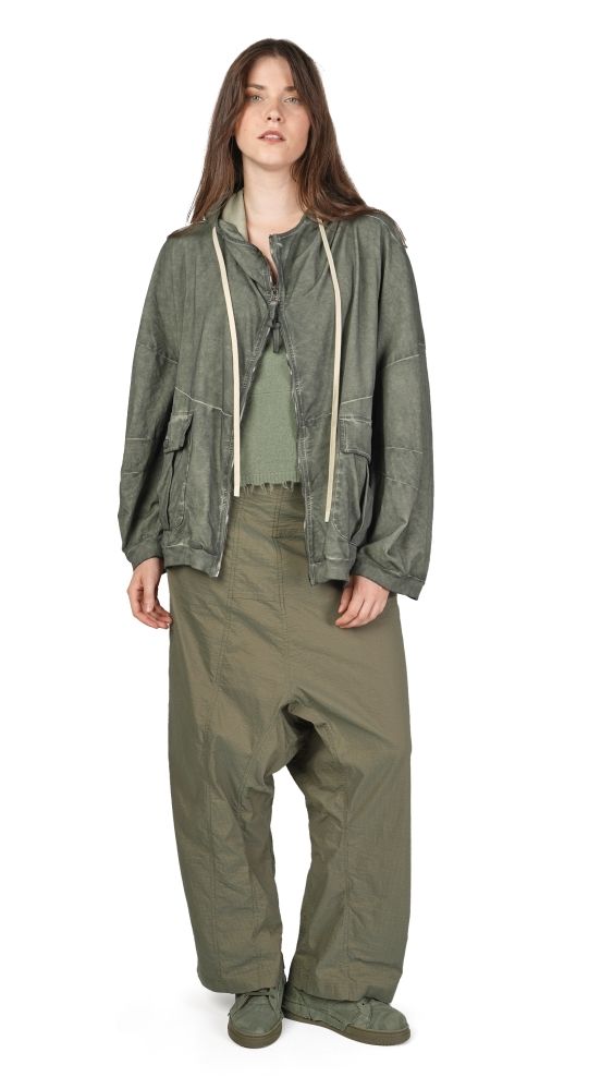 Person trägt olivgrüne Cargo-Jacke mit weitem Schnitt und passende weite Hosen, lässig kombiniert.