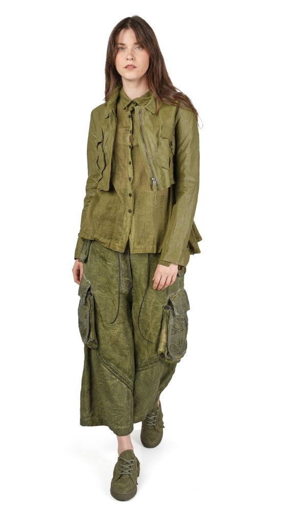 Frau trägt oversized olivgrüne Jacke mit weitem Hosenrock und robusten Schuhen.