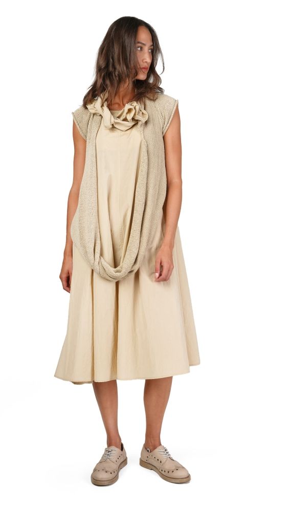 Frau trägt cremefarbenes Kleid mit Spitzen-Ausschnitt und Sneakers, elegant-kasual.