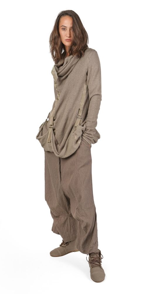 Person trägt bequeme, oversized graue Strickkombi mit weitem Schal und Stiefeln.