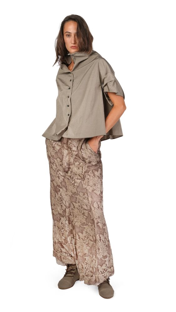 Person trägt oversized beige Hemd mit weitem Rock und robusten Stiefeln.