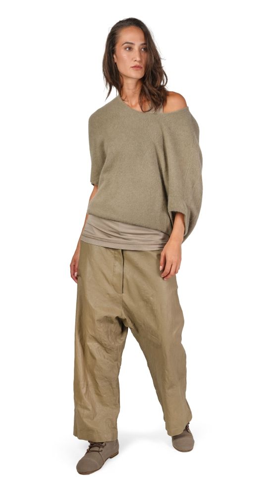 Frau trägt bequeme, oversized khakifarbene Bluse und weite Hosen, natürlicher Look.