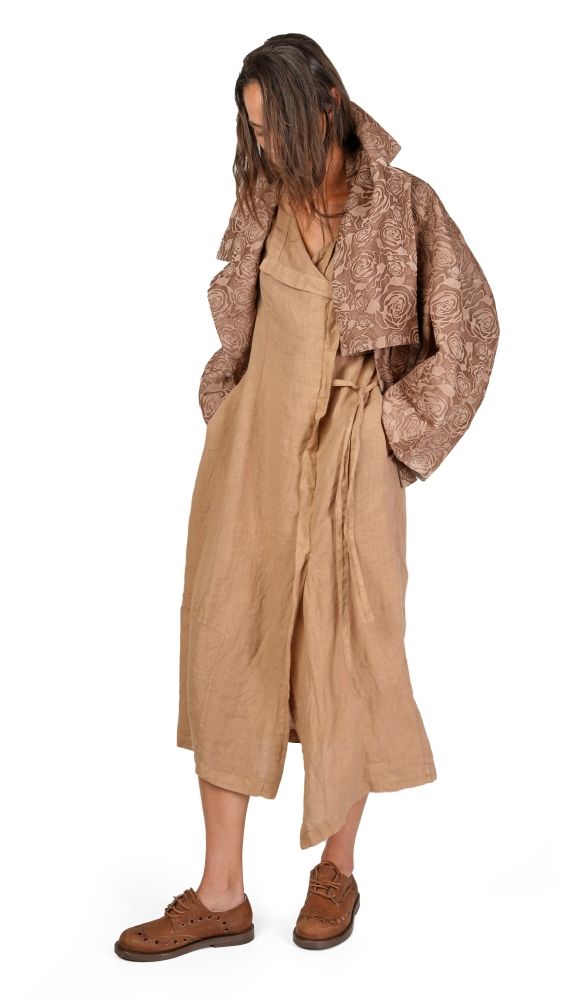 Person trägt beige, langes Wickelkleid mit gemustertem Cape und braunen Schuhen.