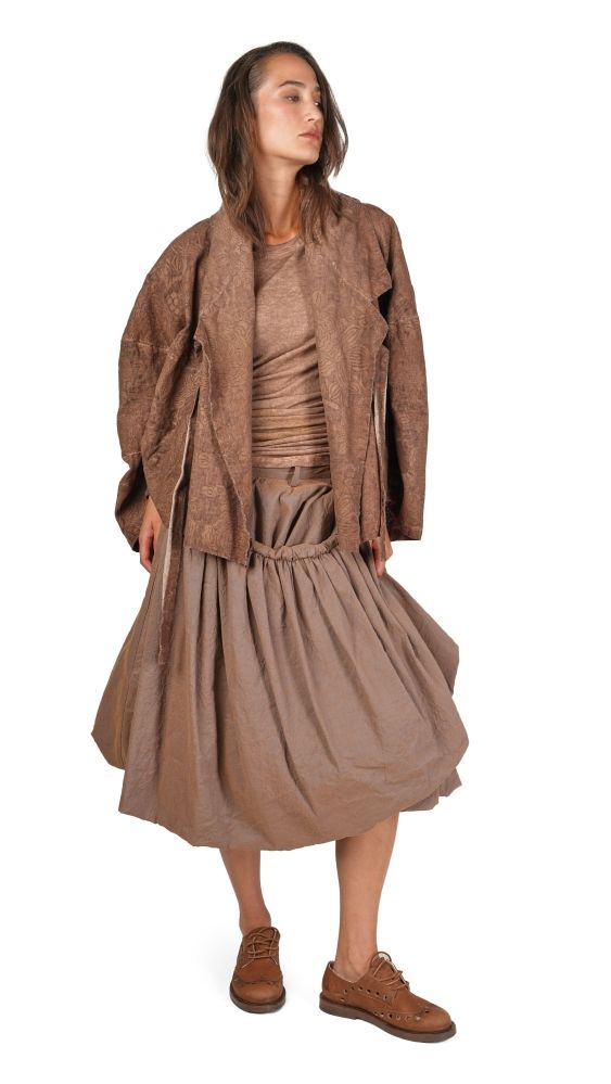 Frau trägt braunen oversized Mantel mit weitem Rock und braunen Stiefeletten, lässiger Stil.
