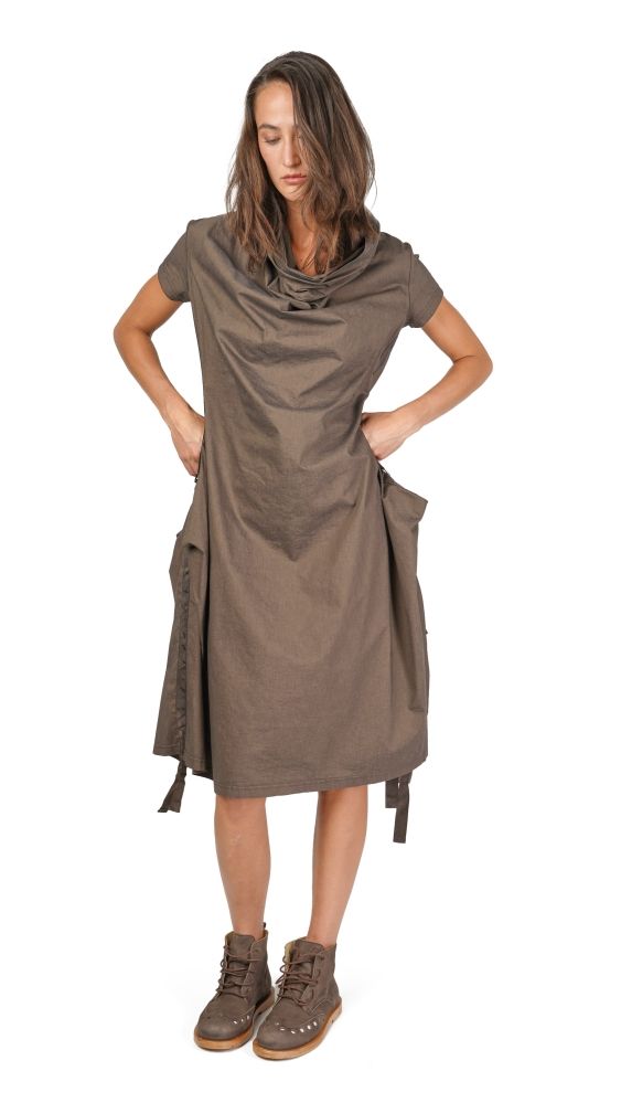Frau trägt oversized braunes Wickelkleid mit Handtasche, steht selbstbewusst, braune Stiefel.