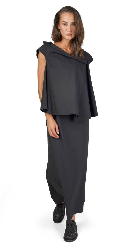 Schlichte schwarze oversized Tunika mit weitem Rock, kombiniert mit schwarzen Stiefeln.