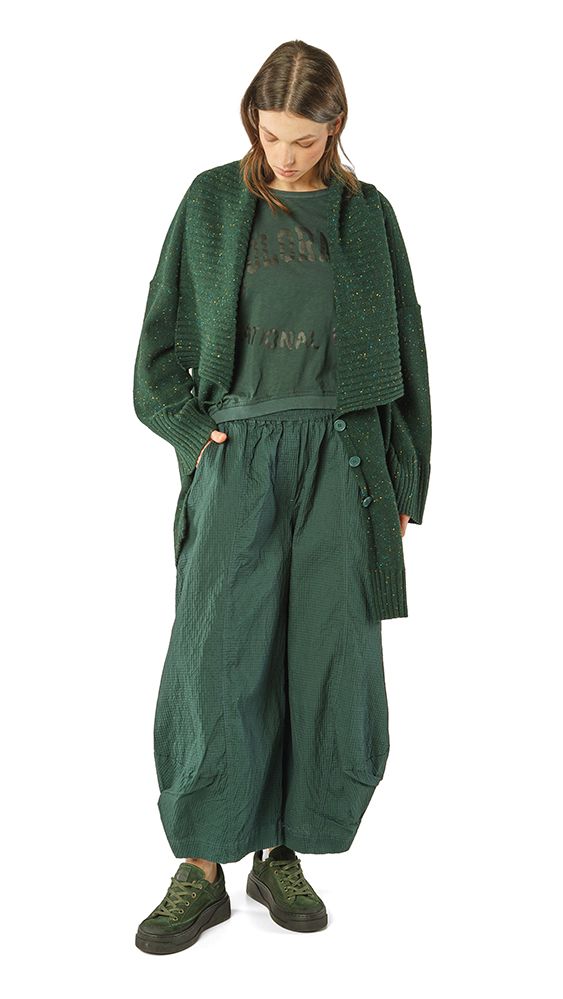 Frau trägt oversized grünes Kleid mit Cardigan und robusten Stiefeln, lässiger Look.