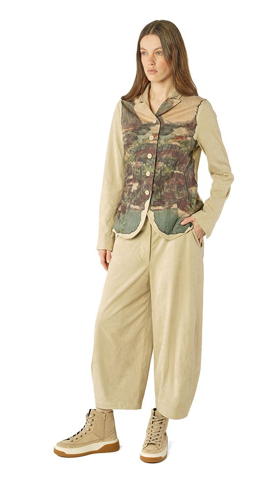Frau trägt oversized Bluse mit floralem Einsatz, weite beige Hose und Sneakers.