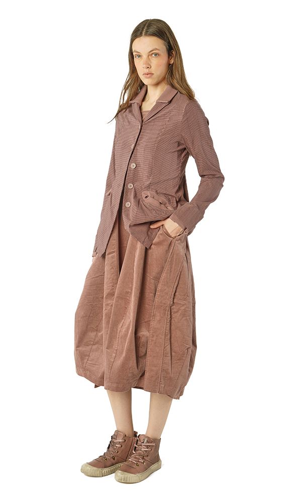 Frau trägt oversized taubenfarbenes Kleid mit Weste und robusten Stiefeln.