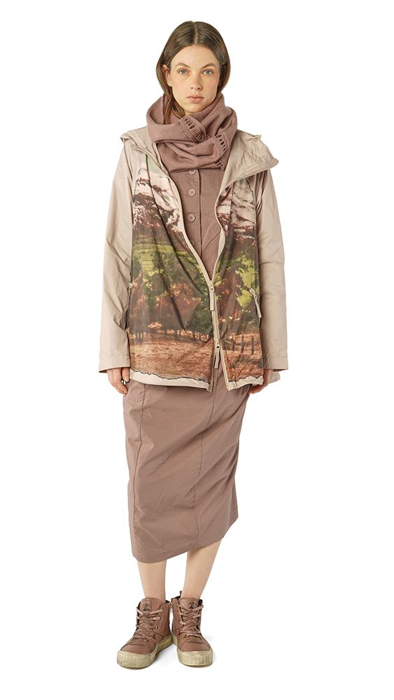 Frau trägt oversized Jacke mit Muster, langer Rock und robuste Stiefel, beige-grau gestylt.