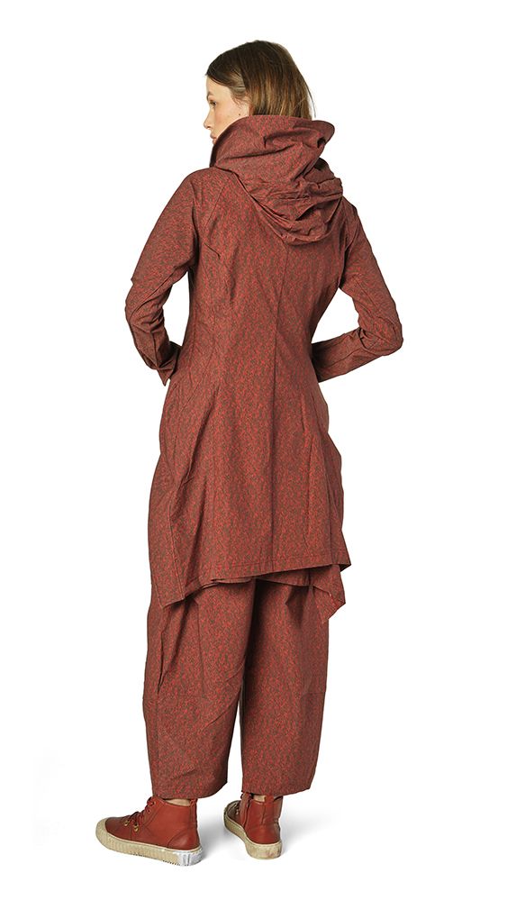 Frau trägt oversized rustfarbenen Textlook mit weitem Schnitt und Kapuze, kombiniert mit beigen Sneakern.