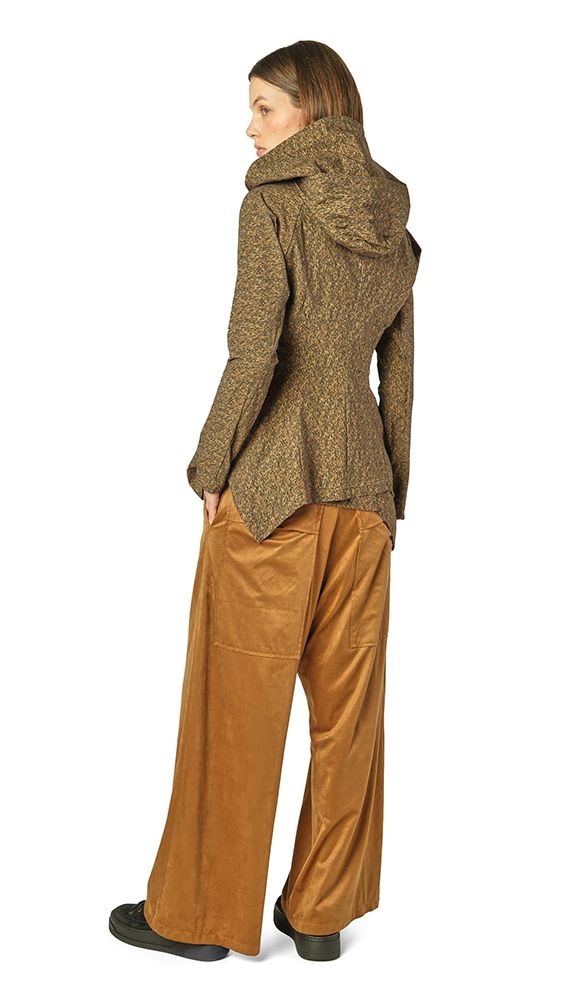 Frau trägt olivfarbenen strukturierten Blazer mit hochgeschlagenem Kragen, beige weite Hosen und schwarze Schuhe.