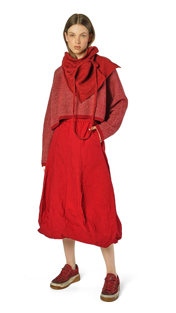 Frau trägt oversized roten Mantel mit Schal, rote Schuhe, lässiger Look.