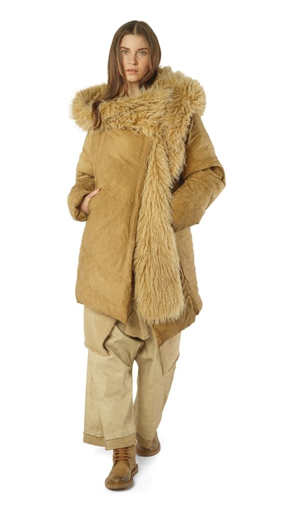 Frau trägt beige Daunenmantel mit Fellkragen und weiten Hosen, steht lässig.
