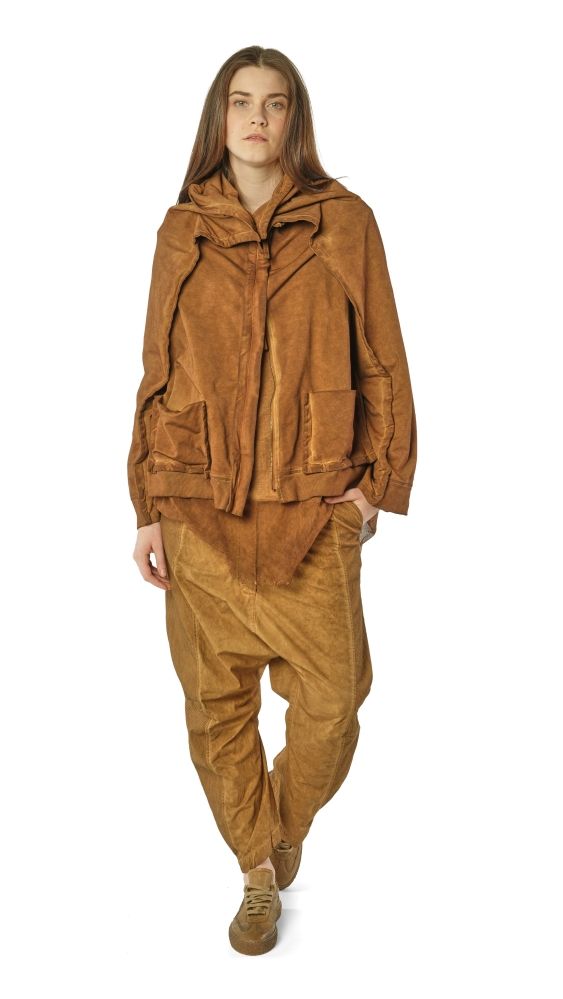 Person trägt beigefarbenen oversized Suede-Jacke mit weitem Hosenanzug und flachen Schuhen.