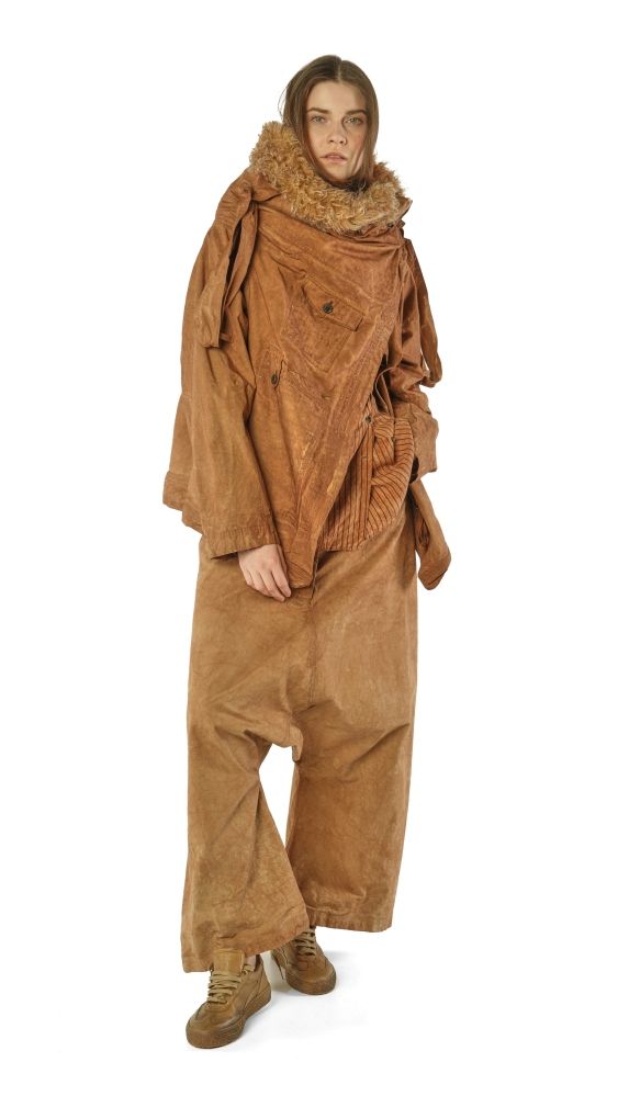 Person trägt oversized braunes Wollkleid mit Fellkragen und robusten Stiefeln.