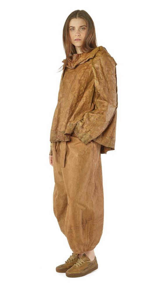 Frau trägt oversized beige Leinen-Jacke und weite Hosen, steht seitlich posierend.
