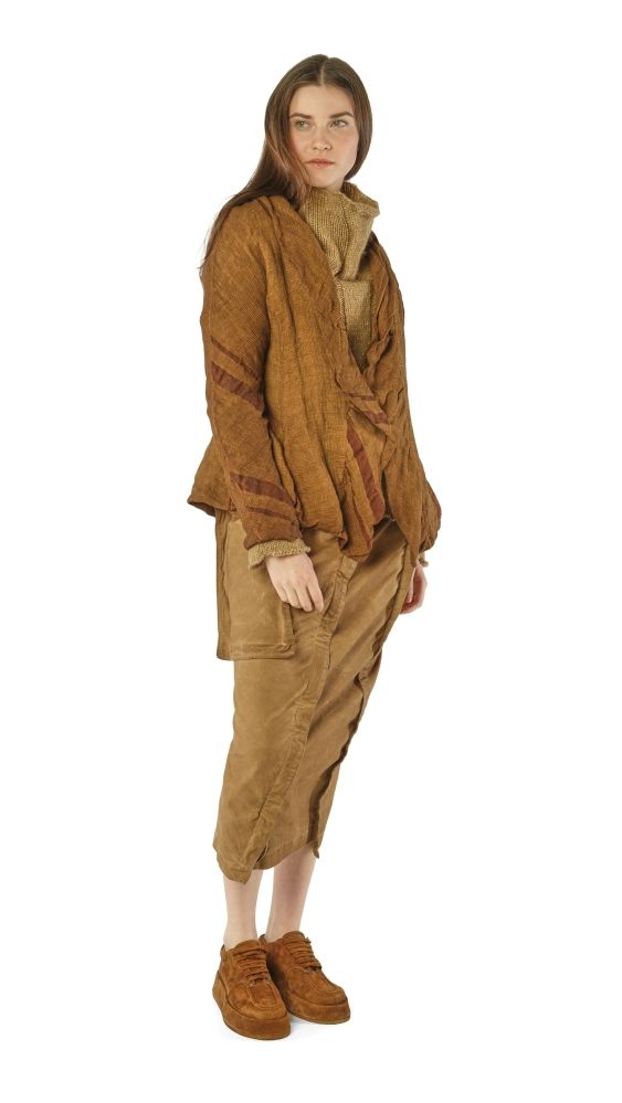 Frau trägt bequeme, braune oversized Kleidung mit weitem Cardigan, weiten Hosen und robusten Schuhen.