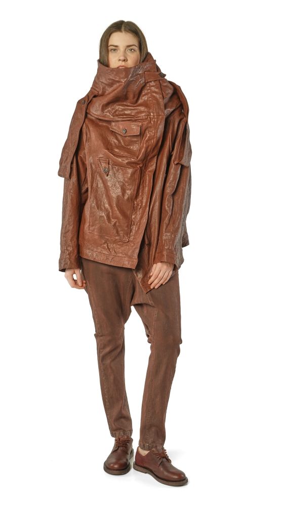 Person trägt oversized braune Lederjacke mit Kapuze und weiten braunen Hosen, kombiniert mit Stiefeln.