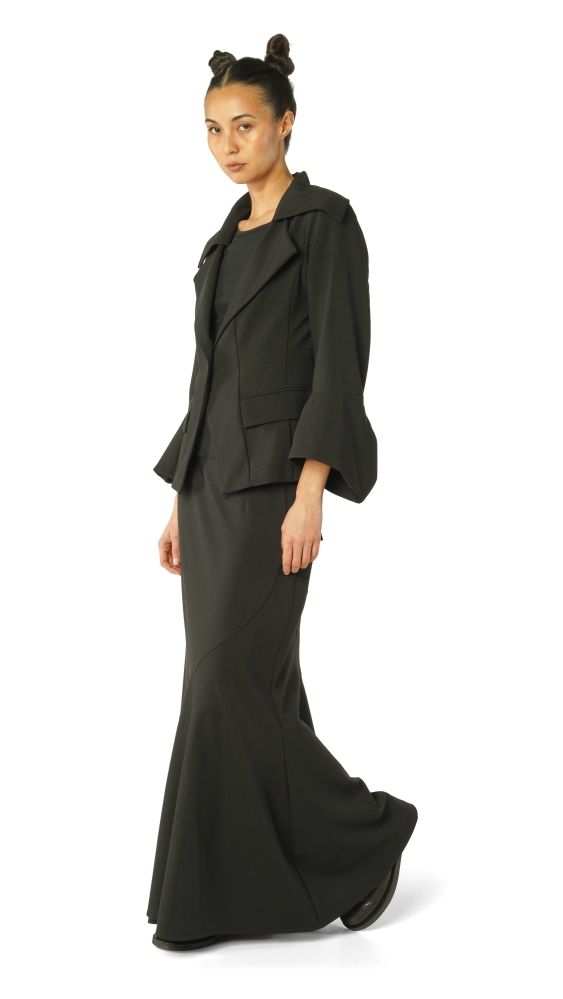Elegante Frau in schwarzem oversized Blazer und langem Wickelkleid, schlicht und modern.