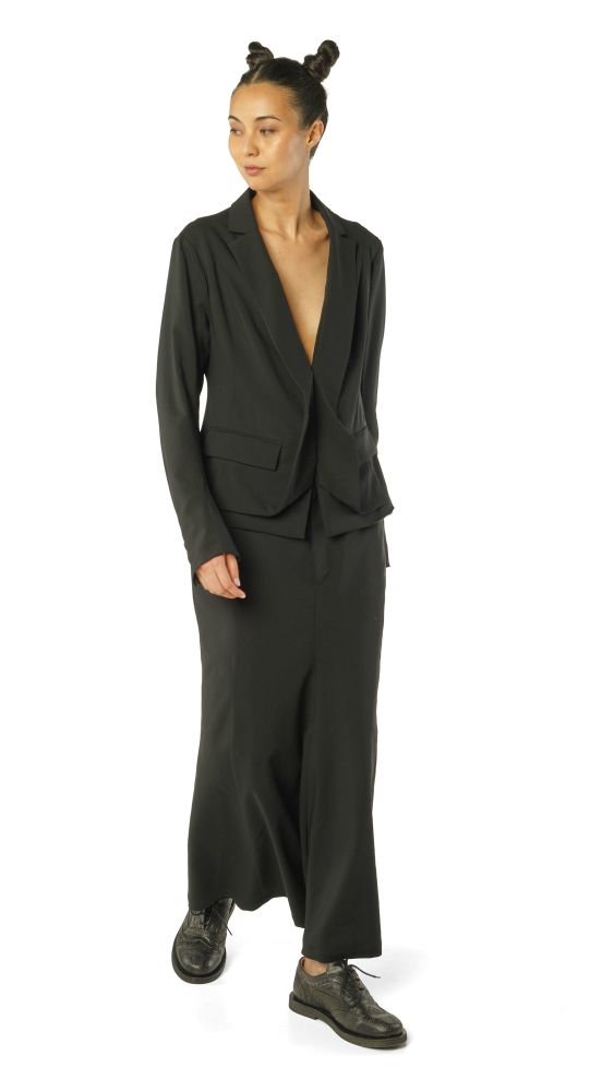 Frau trägt eleganten schwarzen oversized Blazer mit weitem Hosenanzug und bunten Haargummis.