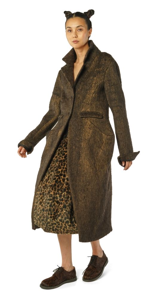 Langer, gemusterter Mantel mit Leopardenfutter und Ohren-Accessoire, kombiniert mit Stiefeln.
