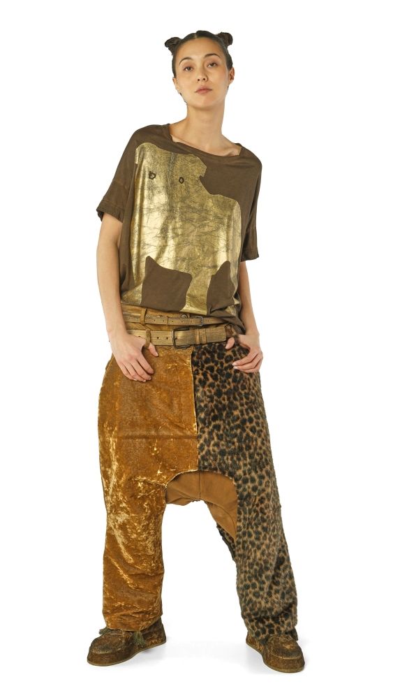 Person trägt bunte, gemusterte Patchwork-Jumpsuit-Kombi mit Accessoires, kreative Streetwear-Optik.