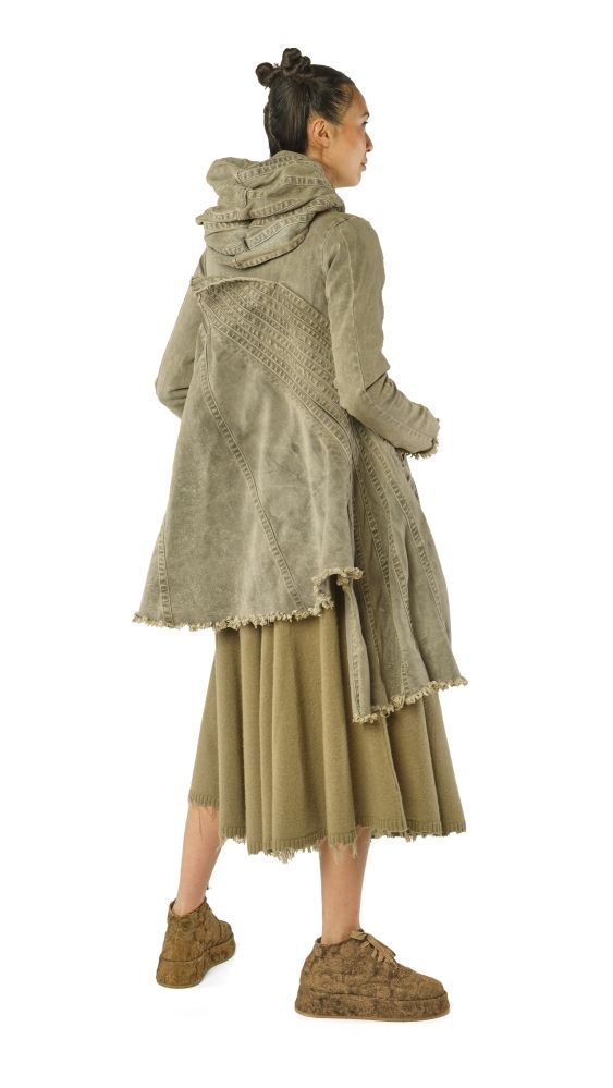 Frau trägt langes, grünliches Wickelkleid mit Fransen und Hoodie, bequeme Schuhe.