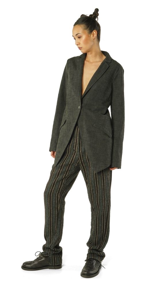 Modische Frau in oversized Blazer, gestreifter Hose und schwarzen Stiefeln.
