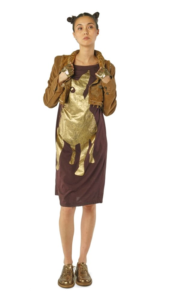 Kostüm mit goldener Kuh-Druck-Optik und braunem Cape, kombiniert mit Stiefeln und Ohren-Accessoire.