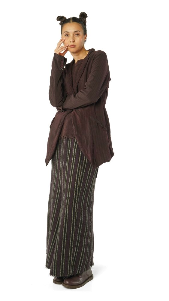 Person in marronem Oberteil und gestreifter Hose, nachdenklich mit Hand am Kinn.