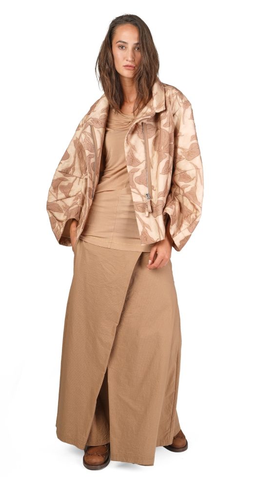 Frau trägt beige Musterjacke, langes Wickelkleid und braune Stiefeletten.