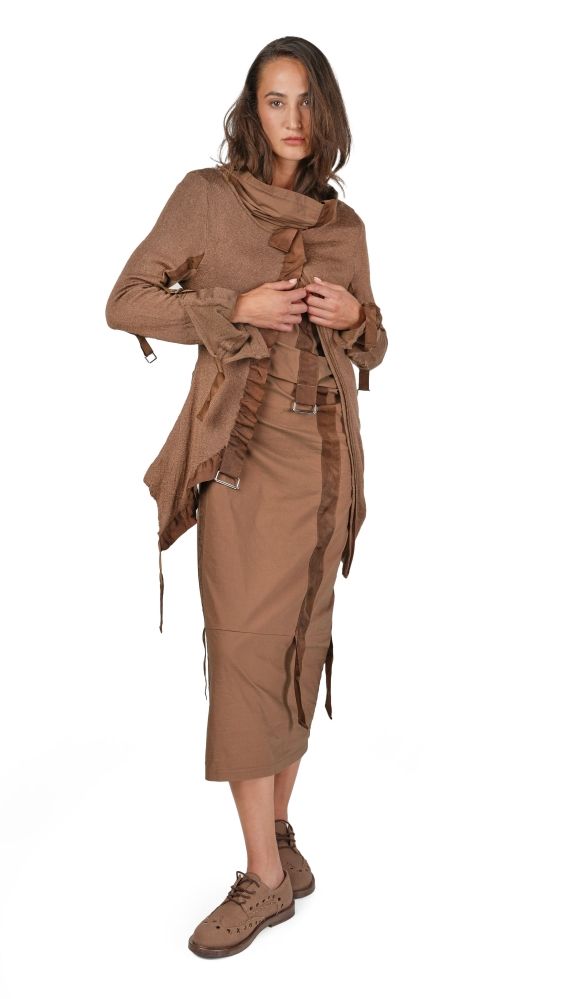 Frau trägt bohemien-inspirierten, braunen Wickelrock mit langem Mantel und Stiefeln, elegant lässig.